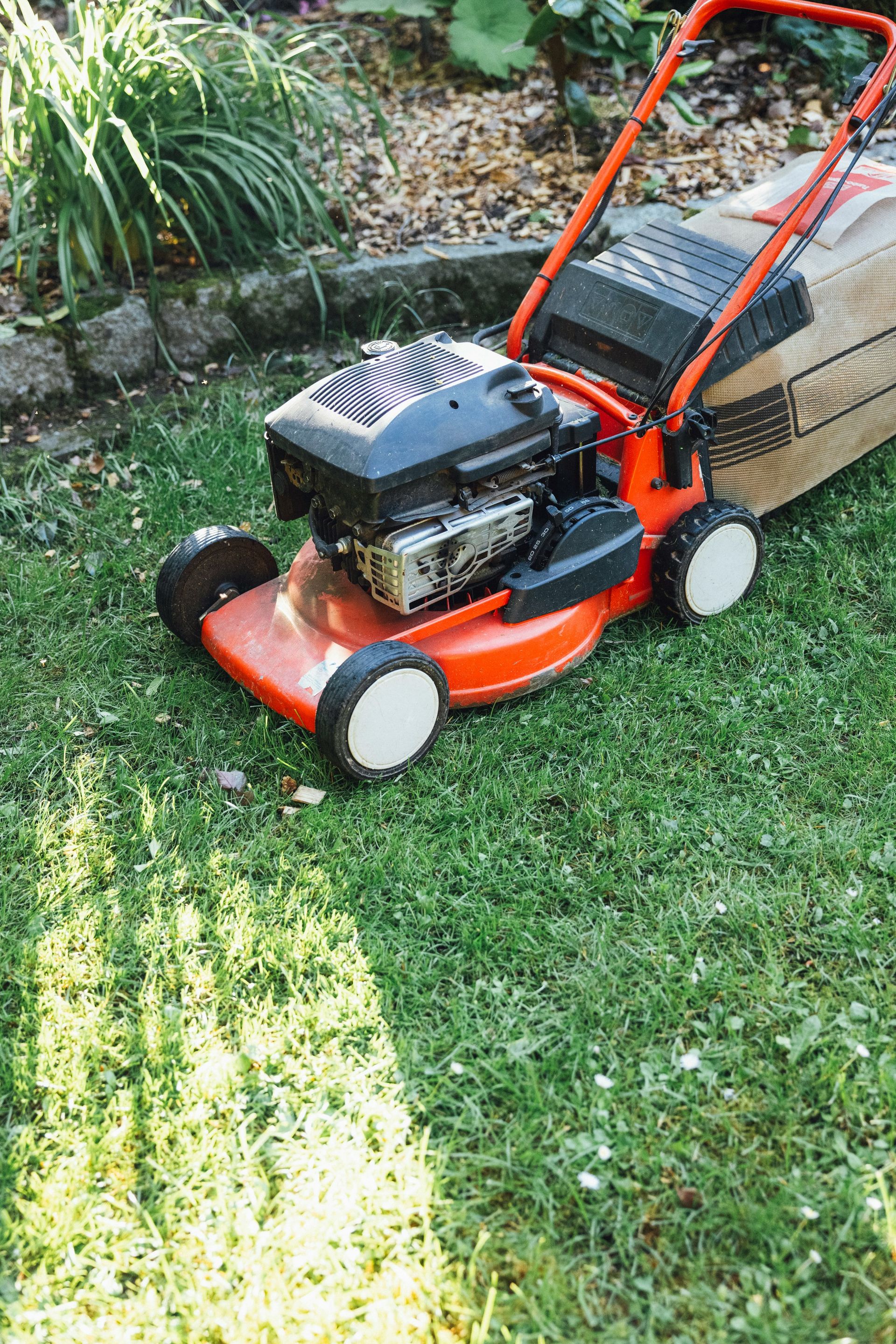 A lawn mower sitting on top of a lush green field